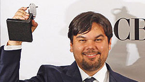 Robert Lopez shows off one of his trophies for <em>The Book of Mormon</em> at the 2011 Tony Awards.