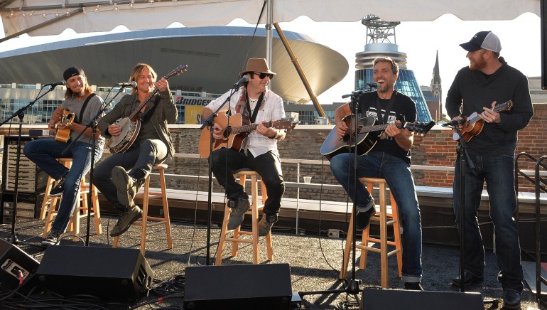 Co-writer Brad Warren, Keith Urban, co-writers Kevin Rudolf and Brett Warren, and producer Nathan Chapman perform on a Nashville rooftop at the “Little Bit of Everything” No. 1 party.

