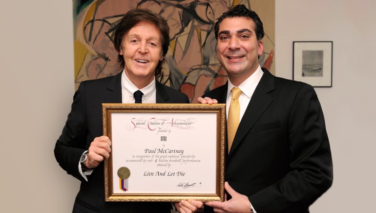 BMI’s Executive Director, Writer/Publisher Relations, Europe and Asia, Brandon Bakshi (right) presents Sir Paul McCartney with a BMI Million-Air Award for his song “Live and Let Die” before the 2012 BMI London Awards.