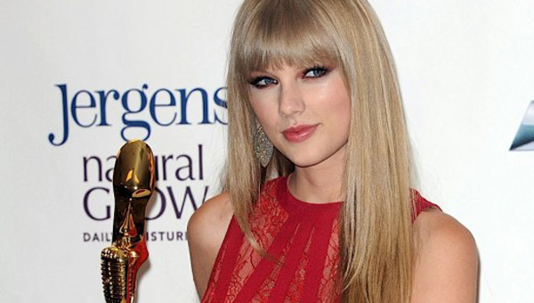 Pictured: Taylor Swift shows off her new Woman of the Year trophy at the 2012 Billboard Music Awards.