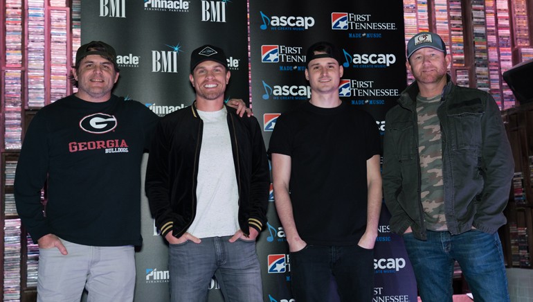 “Small Town Boy” songwriters Rhett Akins, Kyle Fishman and Ben Hayslip gather with Dustin Lynch while celebrating their No. 1 song.