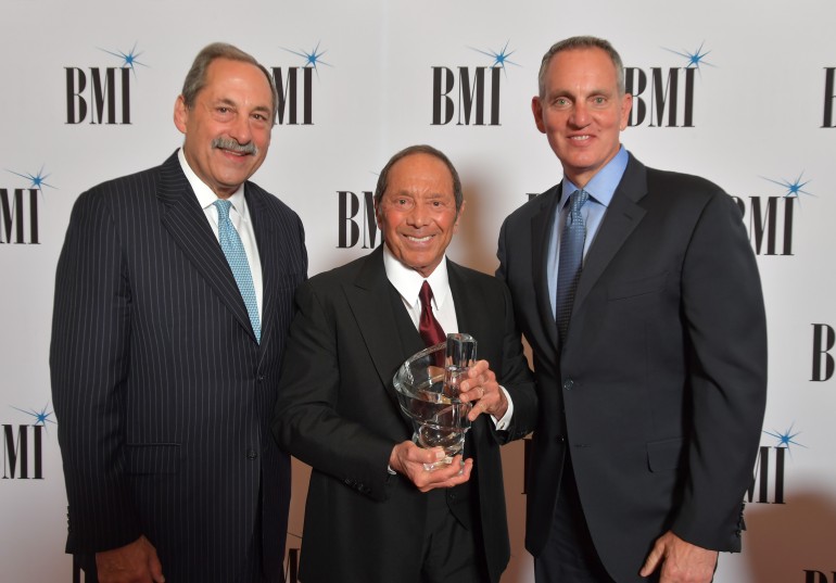 Michael Fiorile, Chairman, BMI Board of Directors & Chairman and CEO, The Dispatch Printing Company and BMI President and CEO Mike O’Neill present Paul Anka with the BMI Board of Directors Award at the 71st Annual BMI/NAB Dinner. 