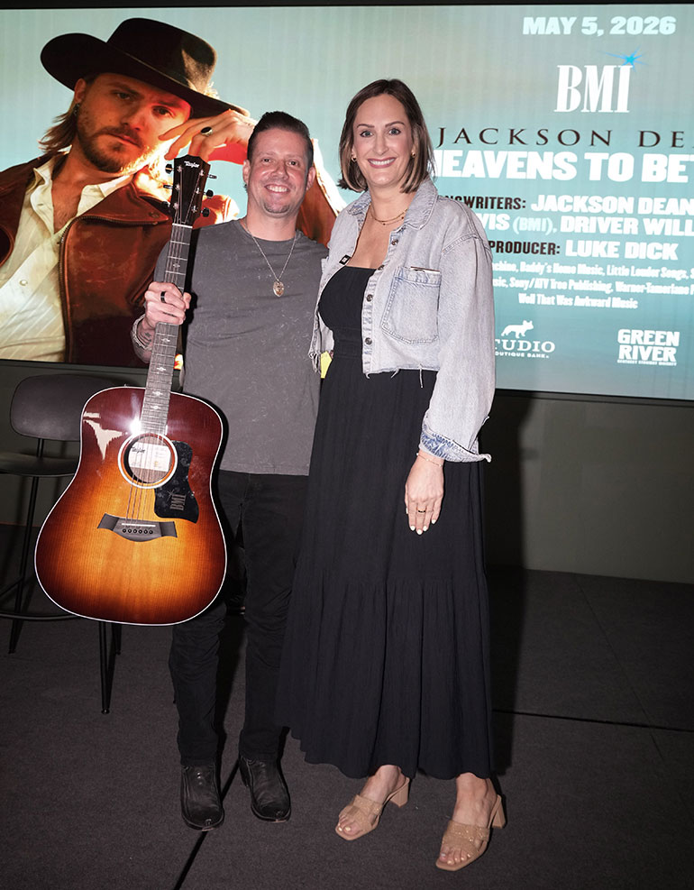 Driver Williams and MaryAnn Keen pose with custom Taylor 210e DLX guitar gifted to Williams