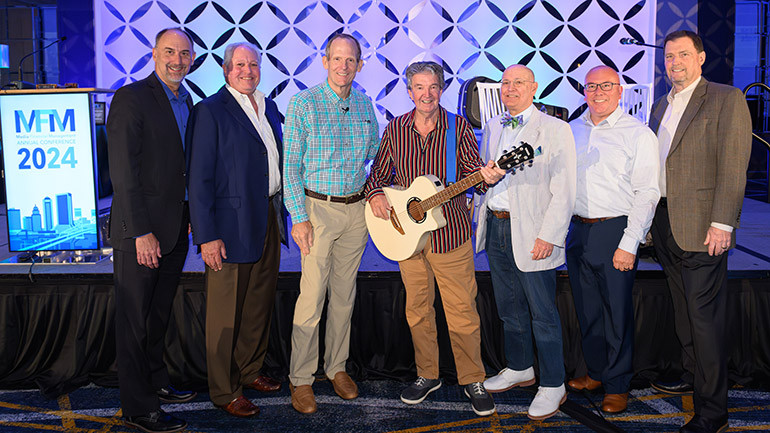 Pictured before Terry Sylvester of the Hollies takes center stage at the Media Financial Management Association Conference in Jacksonville (L to R): Midwest Communications CFO Paul Rahmlow, Szabo Associates President Robin Szabo, BMI’s Dan Spears, The Hollies’ Terry Sylvester, Manship Media CFO Ralph Bender, Dotdash Meredith VP Kevin Schmitz, Media Financial Management CEO Joe Annotti.