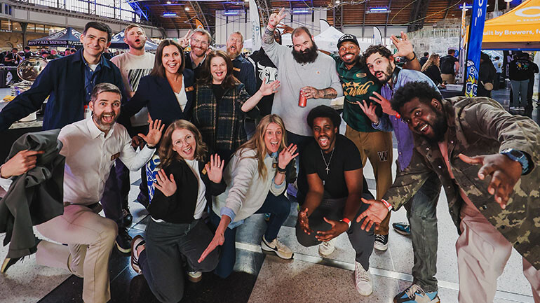 SNACKTIME poses with BMI and Brewers Association (BA) executives during the CBC Welcome Reception at Grand Hall in the Philadelphia Convention Center. First Row (l-r) BA President & CEO Bart Watson, BA Vice President Membership Sarah Billiu, BA Senior Event Manager Tara Forster, and SNACKTIME’s Michael Spearman and Austin Marlow. Second Row (l-r) BMI’s Senior Vice President of Licensing David Levin, BA Vice President of Events & Sales Lacey Gautier, BMI’s AVP of Customer Experience & Engagement Jessica Frost, and SNACKTIME’s Sam Gellerstein, Nico Bryant, and Eric Sherman. Third Row (l-r) SNACKTIME’s co-founder Ben Stockton, BA Vice President of Operations Dan Goloback, BA Event Manager Joe Damgaard and SNACKTIME’s Larry Monroe, Jr.